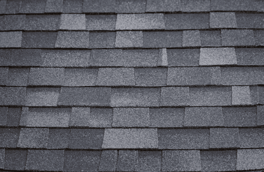 Close-up view of gray asphalt roof shingles arranged in a staggered pattern.