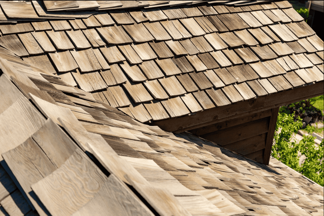 Close-up view of a wooden shingle roof on a building, showing overlapping rectangular shingles in natural light.